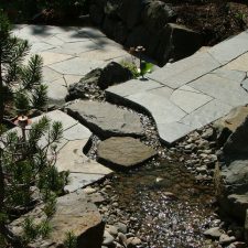 An elaborate stone pathway with a stream of water running through.