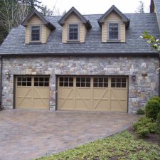 A three-car garage with an immaculate stone veneer.